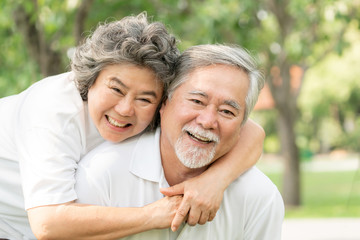 Naklejka premium Happy love Elderly couple smile face , Senior couple old man and senior woman relaxing hug in a forest