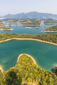 Aerial photography of "mini-island" in Lushan Sea, inlaid with blue water, is like "Jadeite falling jade plate". Natural scenery background.