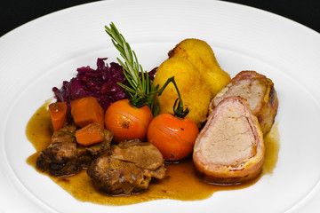 A classic Swiss dinner of pork, red cabbage, roast vegetables and pommes williams