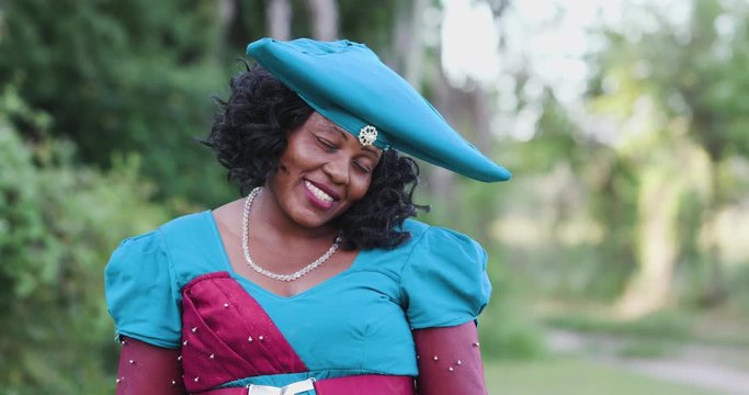 4K close-up portrait of pretty black Herero woman in Traditional Dress looking at the camera 