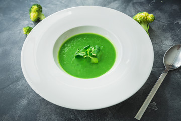Homemade spinach soup in a bowl on gray background