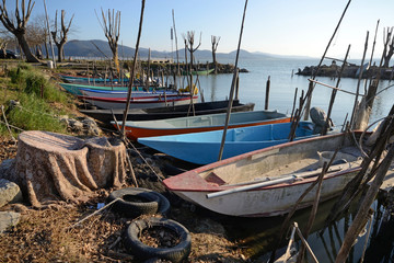 Fototapeta premium scenic view of Trasimeno Lake harbor with moored fishing boats, on springtime