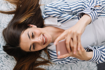 Obraz na płótnie Canvas Girl at home taking selfies with her phone. 