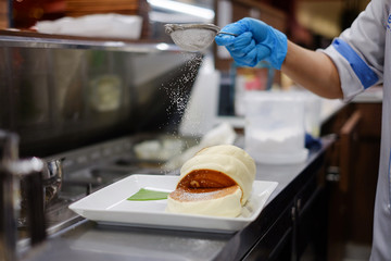 sprinkle with powdered sugar on puffy pancake in kitchen