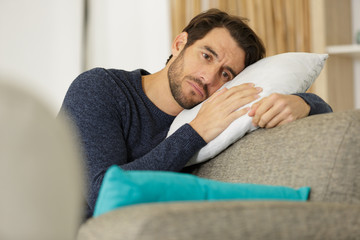 Obraz premium cheerless depressed sad man feeing unhappy on the sofa