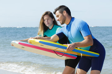 Obraz premium surfers couple with surf boards on the beach