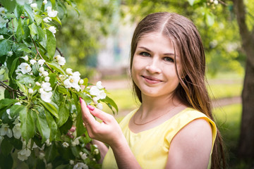 Beautiful young woman near apple tree