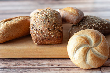 Various baked breads and rolls on wooden table
