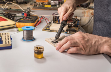 technician electrician prepares rosin soldering iron to work