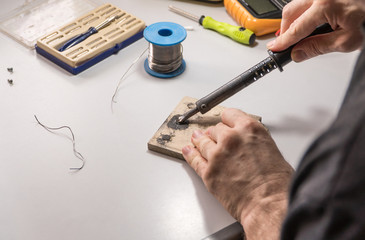 technician electrician prepares rosin soldering iron to work