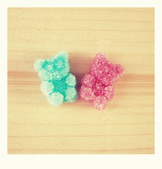 Pink and blue jelly gummy bear on wooden background. Polaroid photo.Pink and blue gummy bear in sugar.  Friendship symbol, girl and boy.