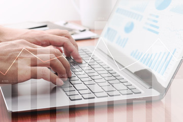 Analyzing statistical data. Using laptop for calculation.Businessman preparing reports. Many graphs and charts.