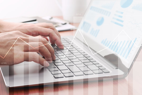 Analyzing statistical data. Using laptop for calculation.Businessman preparing reports. Many graphs and charts.