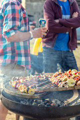 Grill party with friends. Talking guys at the grill. Shallow depth of field.