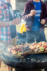 Grill party with friends. Talking guys at the grill. Shallow depth of field.