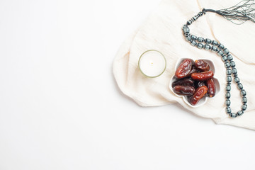 Naklejka premium Ramadan Kareem Festival, Dates at bowl with rosary and white candle the white isolated background