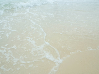 Sea water wave and water foam on beach background