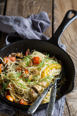 Spaghetti with mushrooms and tomatoes in a pan