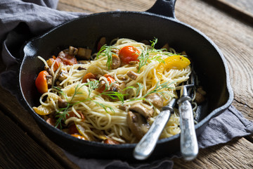 Spaghetti with mushrooms and tomatoes in a pan