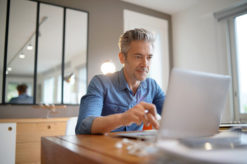 Mature man working from contemporary home - Powered by Adobe