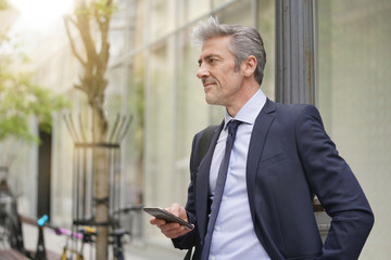 Fototapeta premium Businessman commuting on foot with cellphone