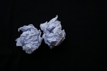 crumpled paper ball and black background