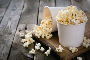 Home made pop corn in white cups on wood background