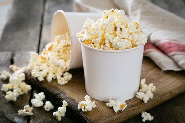 Home made pop corn in white cups on wood background
