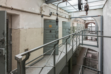 Old prison corridor with open cells.