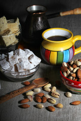A mug of coffee and different oriental sweets: turkish delight, halva, almond and pistachio