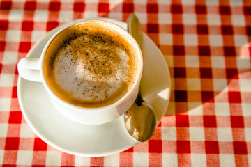 A Cup of cappuccino is on the table in the cafe 