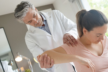 Physiotherapist helping patient with shoulder injury