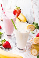 Fresh milk, strawberry, banana on wooden table, assorted protein cocktails with fresh fruits. Natural background. 