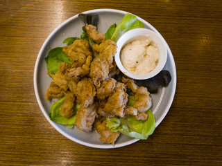 Top view of a plate of fried chicken on a green leaves.