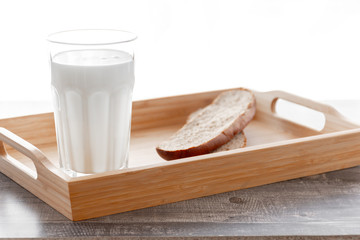 Morning milk glass. Buttermilk dairy drink breakfast on wooden desk. Bread, butter. Ketogenic