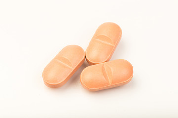 pink  pills close up on white background