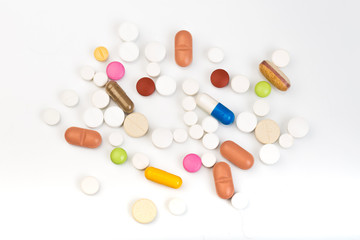 set of multi-colored tablets and capsules on a white background