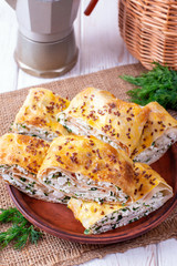 Lavash roll with cottage cheese and greens on a plate