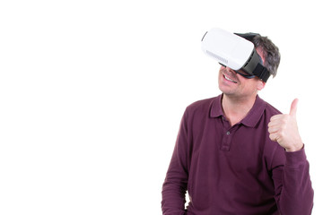 portrait of handsome man playing video games in goggles 3d glasses European player wearing virtual reality headset for smart phone thumbs up smiling standing against white background wall