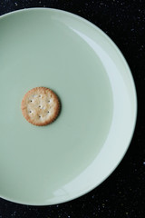 biscuit cracker on white plate with tea spoon
