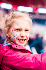 staged photo. girl blonde on the podium. there is an inscription on the cheek. she is glad that the team is winning. there is toning.
