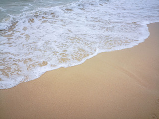 Sea water wave and water foam on beach background