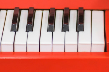Naklejka premium Top view of piano black and white keys with red side. Close-up of piano keys. Close frontal view.