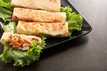 Plate with tasty fried spring rolls on table