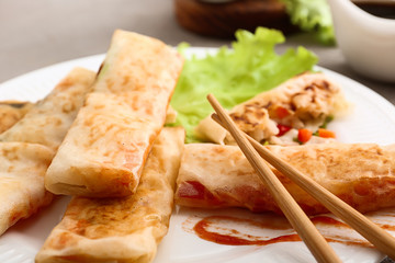 Eating of tasty fried spring rolls, closeup