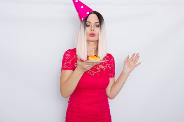 Blond in party hat holding cake