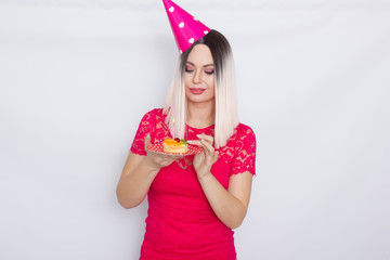 Blond in party hat holding cake