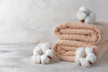 Cotton flowers with soft towels on light table