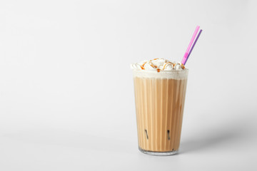 Glass of tasty frappe coffee on light background