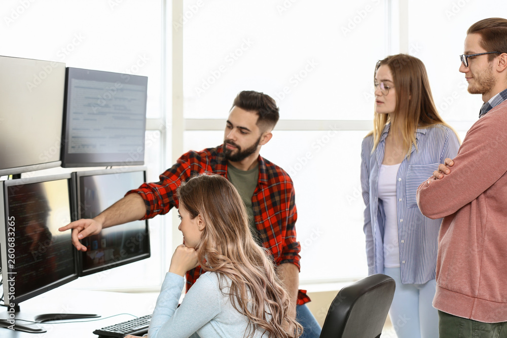 Poster team of programmers working in office